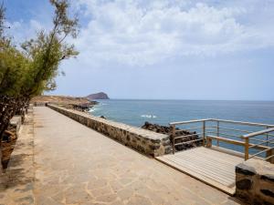 a walkway leading to the ocean with a view at Las Rocas by the Ocean, Wifi and Sea View in Los Abrigos