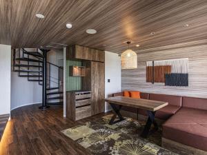 a living room with a wooden ceiling and a wooden table at TWIN LINE HOTEL YANBARU OKINAWA JAPAN Formerly Okinawa Suncoast Hotel in Nago