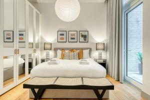 a bedroom with a large bed and a large window at JOIVY Luxury flats near Big Ben and London Eye in London