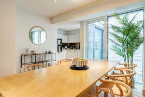 a kitchen and dining room with a wooden table and chairs at Westminster Fire Station Luxury Apartments in London +248 photos