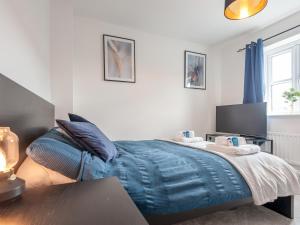 a bedroom with a bed with a blue blanket at Pass the Keys Bramhope Haven in Leeds