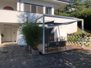 a pergola with a bench in front of a house at B&B Palazzina10 in Sasso Marconi