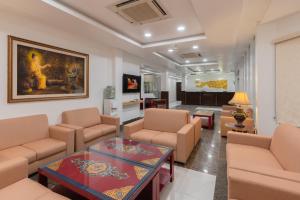 Hotel Ratnasambhava في Lumbini: غرفة معيشة مع أريكة وكراسي وطاولة