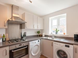 a kitchen with a washing machine and a washer at Pass the Keys Bramhope Haven in Leeds