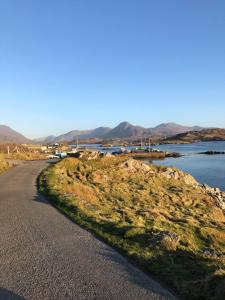 eine gewundene Straße neben einem Wasserkörper in der Unterkunft Bruíon Connemara in Cleggan