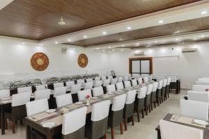 um grande salão de banquetes com mesas e cadeiras brancas em Hotel Ratnasambhava em Lumbini