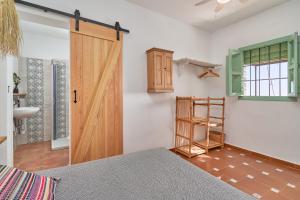 a bedroom with a wooden door in a room at Cortijo de Arriba in Frigiliana