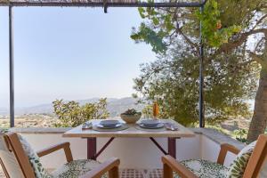 a table and chairs on a balcony with a view at Cortijo de Arriba in Frigiliana