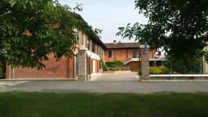 un edificio de ladrillo rojo con un árbol delante de él en Albergo del Po, en Viadana