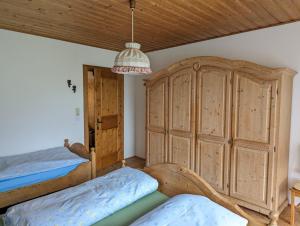 een slaapkamer met 2 bedden en een grote houten kast bij Neuschwendterhof in Ebbs