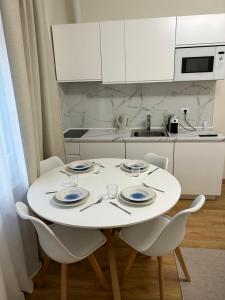 a white kitchen with a white table and chairs at Casa di Ale Venezia in Mestre