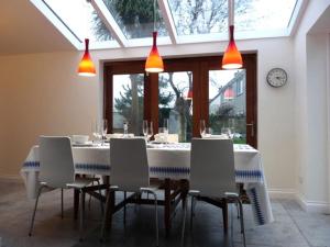 a dining room with a table with chairs and lights at Spring Cottage,Gorgeous and Hi-spec in Kilkhampton +12 photos