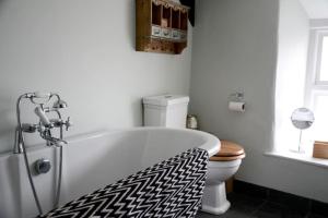 a bathroom with a white tub and a toilet at Spring Cottage,Gorgeous and Hi-spec in Kilkhampton
