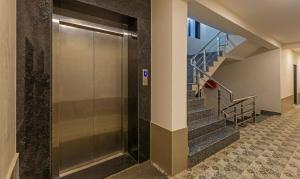 un pasillo con escaleras y un ascensor en un edificio en Treebo Trend Oscar, en Rajkot
