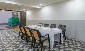 una sala da pranzo con tavolo e sedie di Treebo Trend Oscar a Rajkot