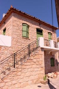un edificio in pietra con balcone sul lato di Artists' Residence 2 bed, 2 bath a Megalochori (Isola di Agistri)