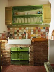 a kitchen with green cabinets and tiles on the wall at Artists' Residence 2 bed, 2 bath in Megalochori