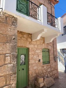 a building with a green door and a balcony at Artists' Residence 2 bed, 2 bath in Megalochori