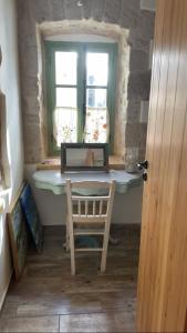 een kamer met een tafel, een stoel en een raam bij Artists' Residence 2 bed, 2 bath in Megalochori