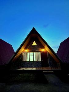 una casa con techo inclinado y ventanas por la noche en SYLWAN-O SUNRISE HOMESTAY, 