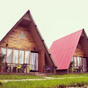 una casa con techo rojo y mesa en SYLWAN-O SUNRISE HOMESTAY, 