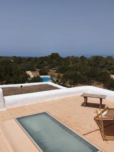 a swimming pool with a table and a bench on a patio at Els Castells in Illes Balears