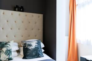 a bedroom with a bed with palm trees pillows at Quentin Amsterdam Hotel in Amsterdam