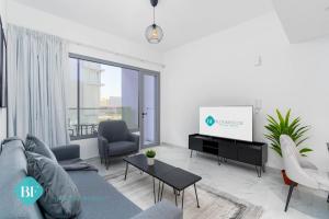 a living room with a couch and a tv at Executive 1 Bedroom In Oasis in Abu Dhabi