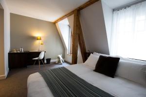 Postel nebo postele na pokoji v ubytování Hôtel des Voyageurs Boutique