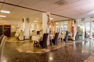 a restaurant with tables and chairs in a room at Aphrodite Hotel in Zalakaros