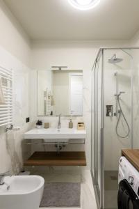 bagno bianco con lavandino e doccia di TRIESTinn - Suite Borsa a Trieste