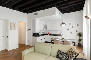 sala de estar con sofá y cocina en TRIESTinn - Suite Borsa, en Trieste