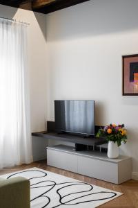 un soggiorno con TV a schermo piatto su un centro di intrattenimento di TRIESTinn - Suite Borsa a Trieste
