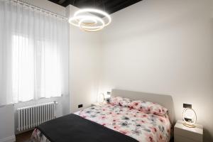 Dormitorio blanco con cama y ventana grande en TRIESTinn - Suite Borsa, en Trieste