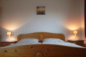 1 dormitorio con 1 cama de madera y 2 lámparas en Harms, Ferienwohnung, en Südbrookmerland