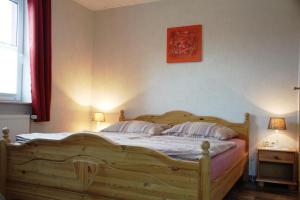 1 dormitorio con 1 cama de madera y 2 almohadas en Harms, Ferienwohnung, en Südbrookmerland