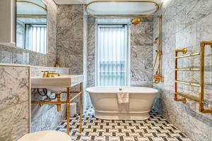 a bathroom with a tub and a sink at Westminster Fire Station Luxury Apartments in London