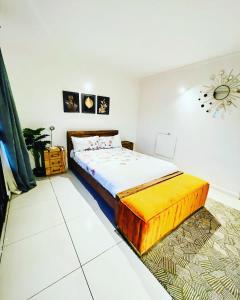 ein Schlafzimmer mit einem Bett und einer Uhr an der Wand in der Unterkunft Soft petal in Pretoria