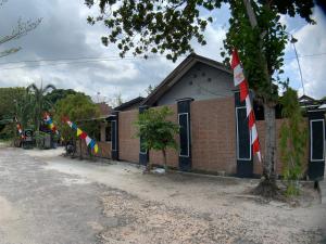 un bâtiment avec des drapeaux sur son côté dans l'établissement Wisma Madagaskar Palangka Raya, à Palangka Raya