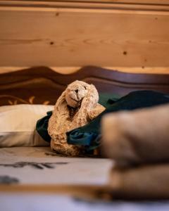 a stuffed animal sitting on top of a bed at Domek Parzenica z balia in Poronin