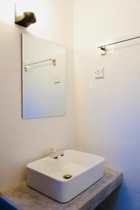 uma casa de banho com um lavatório branco e um espelho. em Soul Inn em Ahangama