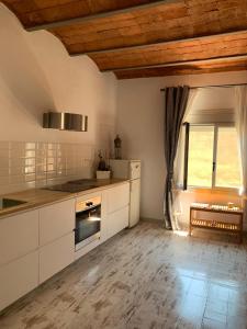 a kitchen with white cabinets and a large window at BlauMasnou One step to the beach! in El Masnou