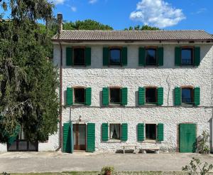 a building with green shuttered windows and a bench at Eco Farm - La Cavallina in Rivoli Veronese