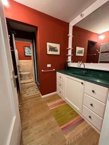 a bathroom with red walls and a sink and a toilet at Cavallina Retreat in Rivoli Veronese +13 photos