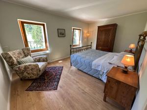 a bedroom with a bed and a chair and a table at Eco Farm - La Cavallina in Rivoli Veronese