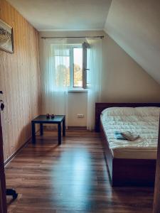 Dormitorio pequeño con cama y mesa en Antano Budriaus sodyba, en Lopaičiai