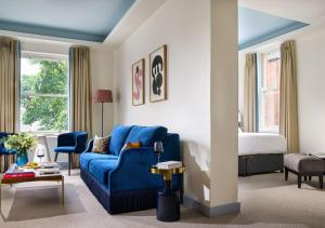 a living room with a blue couch and a bed at Dylan in Dublin