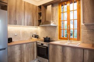 a kitchen with wooden cabinets and a sink and a window at Villa Terrestre in Lakithra