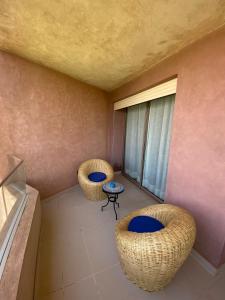 um quarto com duas cadeiras, uma mesa e uma janela em Marrakech - Prestigia Golf - haut standing em Marrakech