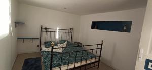 1 dormitorio con 1 cama con edredón verde en La Grangette 24540 Vergt de Biron, en Saint-Martin-de-Villeréal